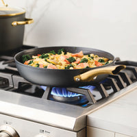 Vegetables and pasta sizzle in the Forged Induction Ceramic 12.25-Inch Frying Pan on a gas stove, their flavors mingling beautifully on its nonstick surface.