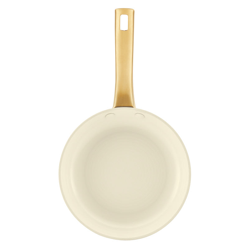 A top-down view of the Forged Induction 8.25-Inch Frying Pan's interior, featuring a smooth, cream-colored nonstick surface. The long, gold-tone handle is positioned vertically at the top, showing the double-rivet attachment and the signature hollow-center design with a hanging hole.
