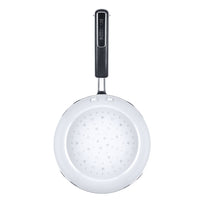 White frying pan with a black handle and heart patterns inside.