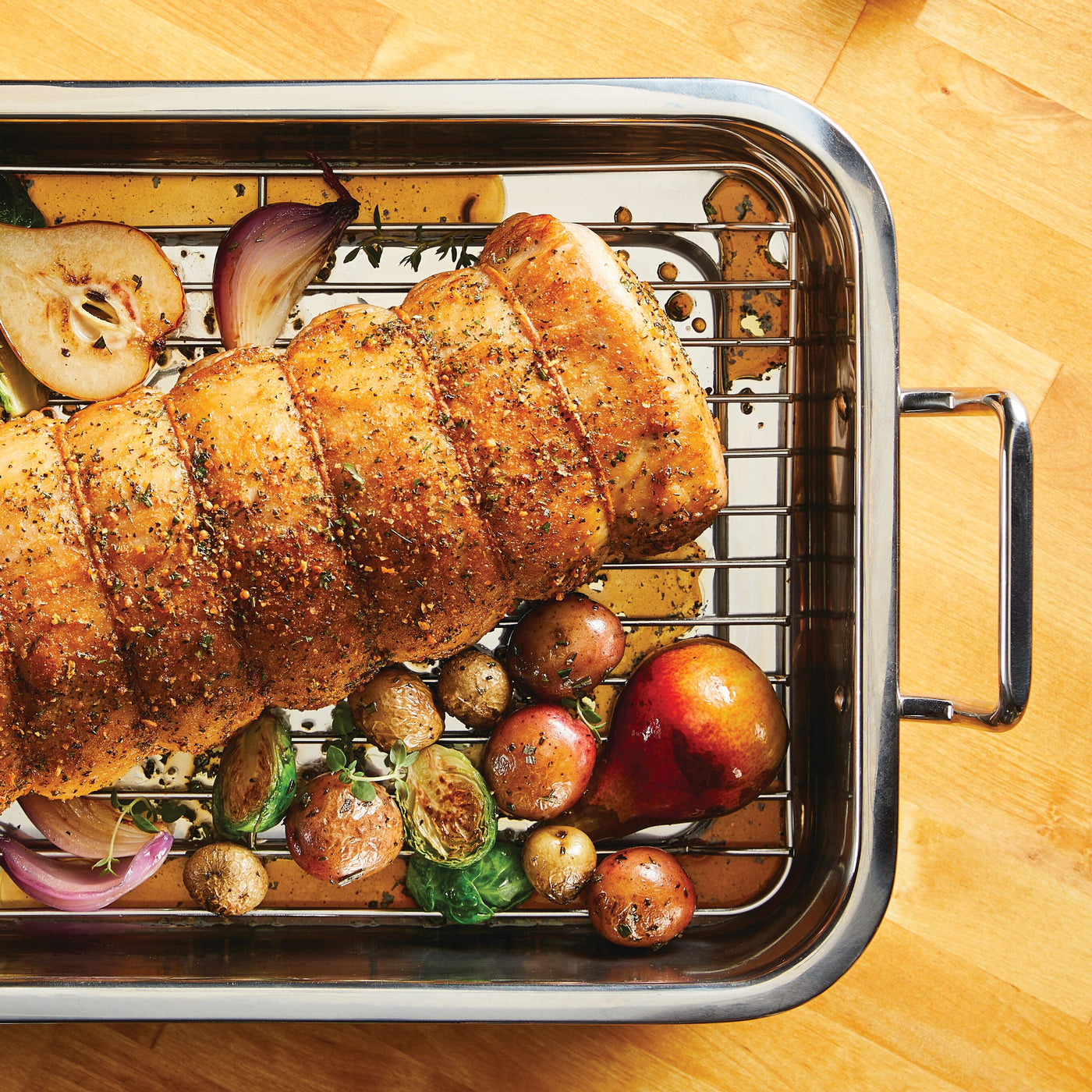 Prepare roast pork with potatoes, onions, and pears in the 17" x 12.25" Stainless Steel Roaster with Rack for even cooking.