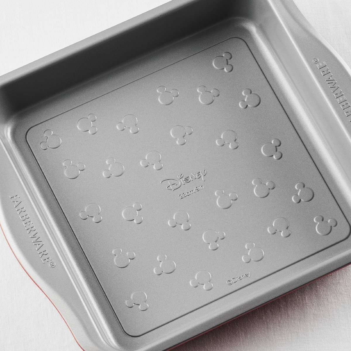 Square baking pan with Mickey Mouse patterns on the bottom surface.