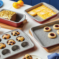 Baking trays with a variety of desserts and baked goods on a table.