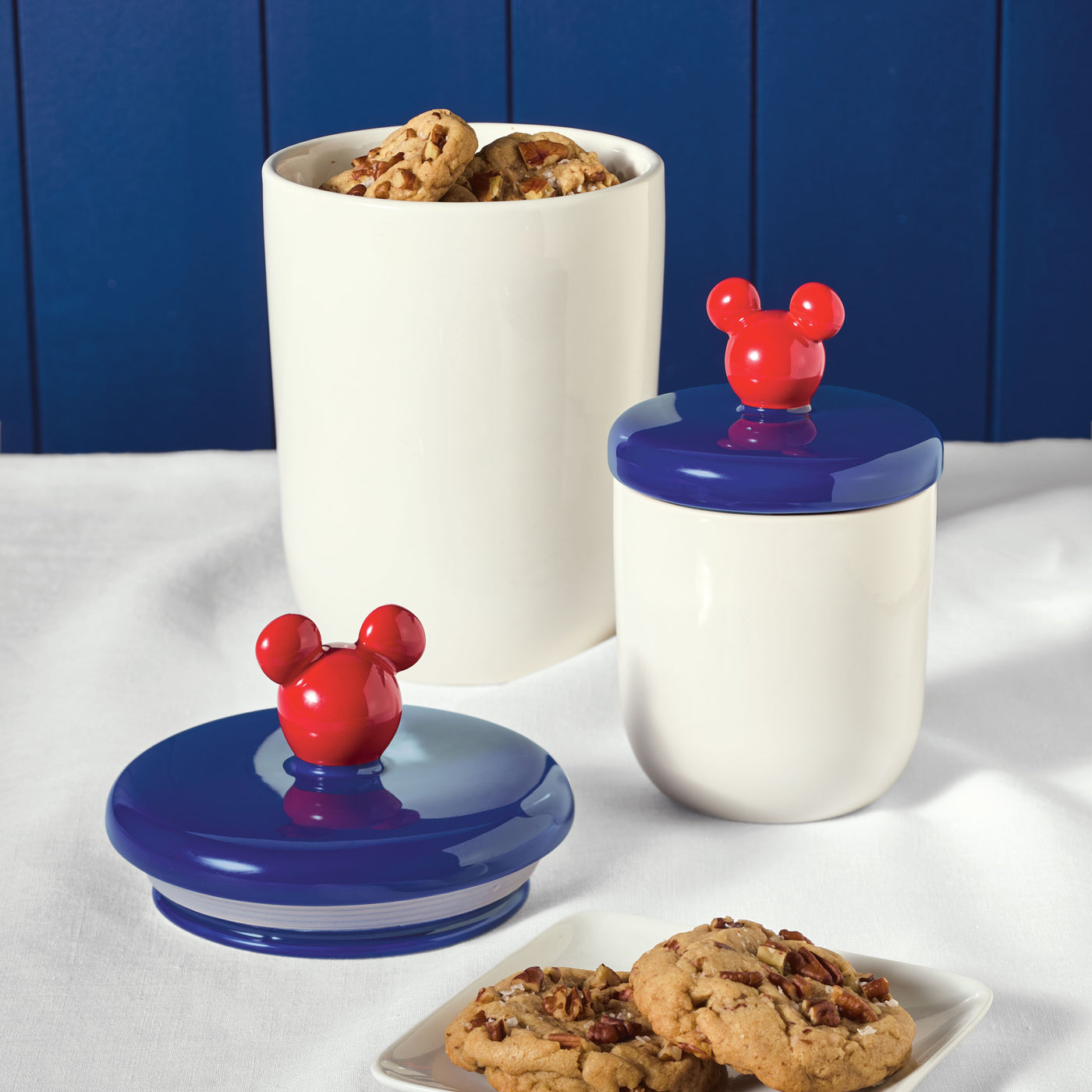 Part of the Bon Voyage collection, the Bon Voyage 2-Piece Ceramic Jar Set includes ceramic jars with vibrant red Mickey ear lids, ideal for storing your favorite cookies.