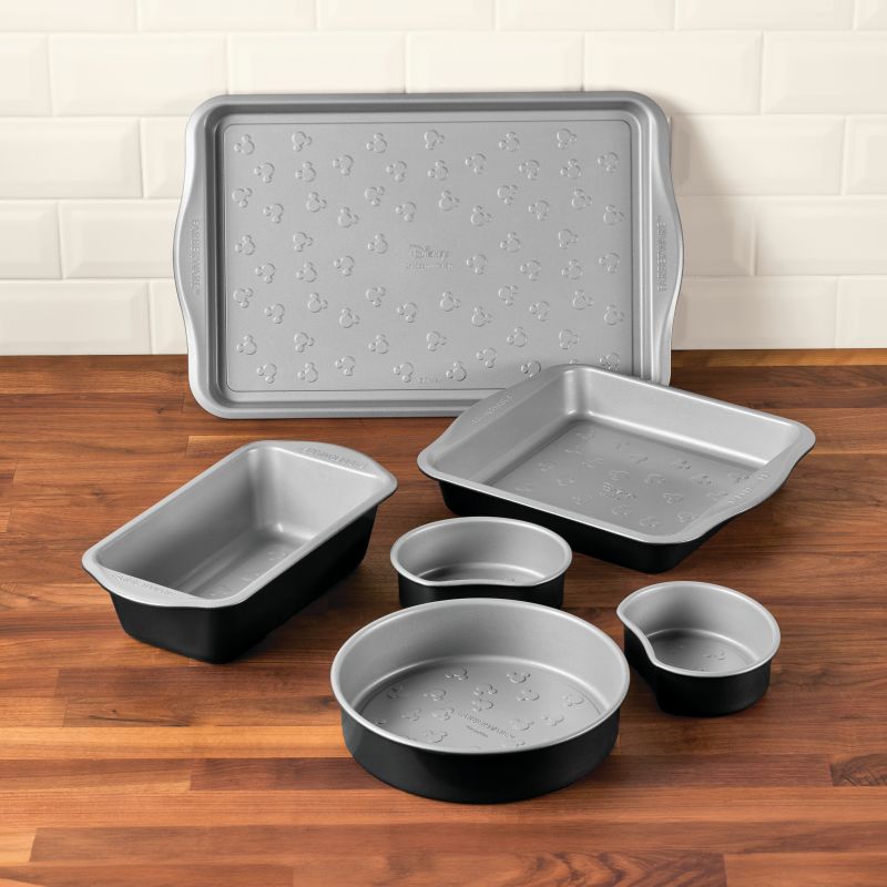 A 6-piece bakeware set on a wooden countertop.