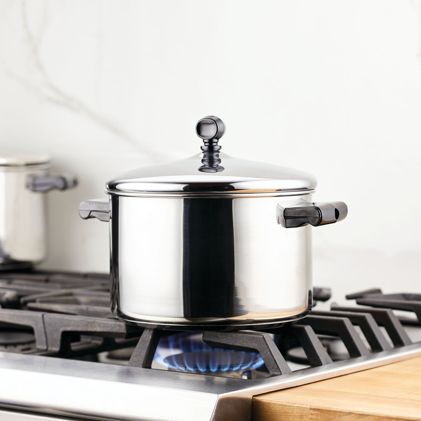 The Classic Series Stainless Steel 4-Qt. Saucepot on a gas stove burner with a blue flame beneath is perfect for making creamy mashed potatoes. Plus, it's dishwasher safe for easy cleanup.