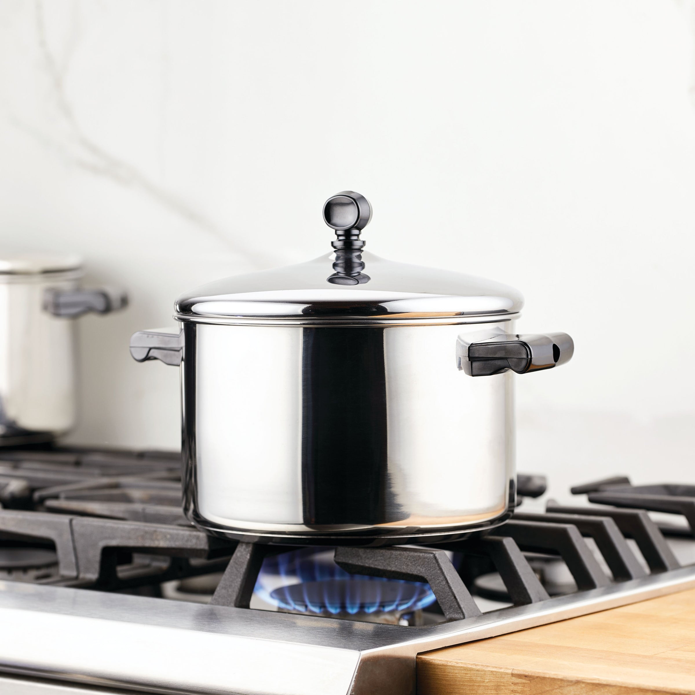 The Classic Series Stainless Steel 4-Qt. Saucepot on a gas stove burner with a blue flame beneath is perfect for making creamy mashed potatoes. Plus, it's dishwasher safe for easy cleanup.