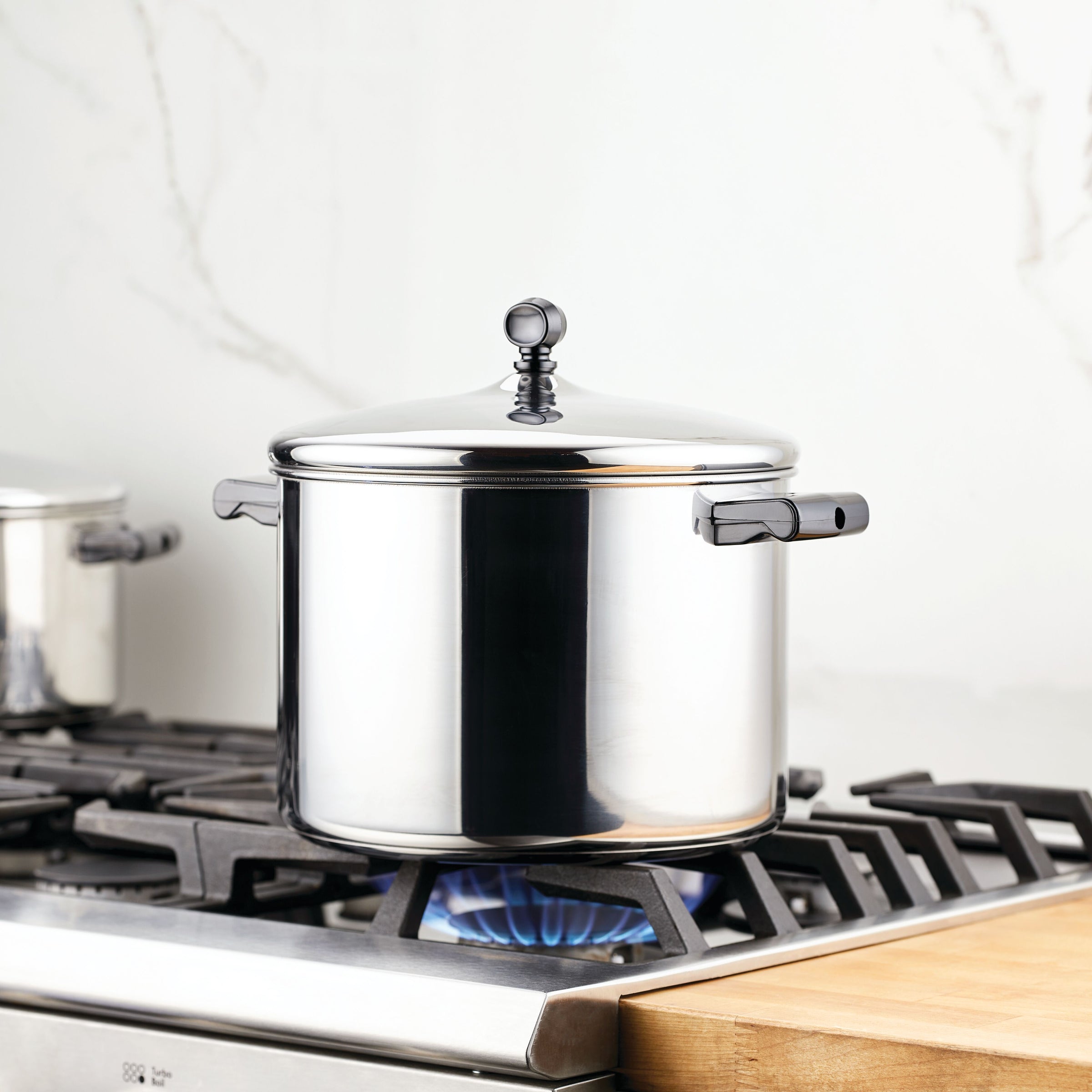 The Classic Series Stainless Steel Stockpot with Lid, when used on a gas stove with a blue flame, guarantees long-lasting performance and exceptional durability.