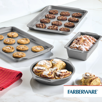 The 4-Piece Nonstick Bakeware Set, featuring four sleek pans perfect for cookies and pastries, sits gracefully on a marble surface, offering easy cleanup after your delightful culinary creations.