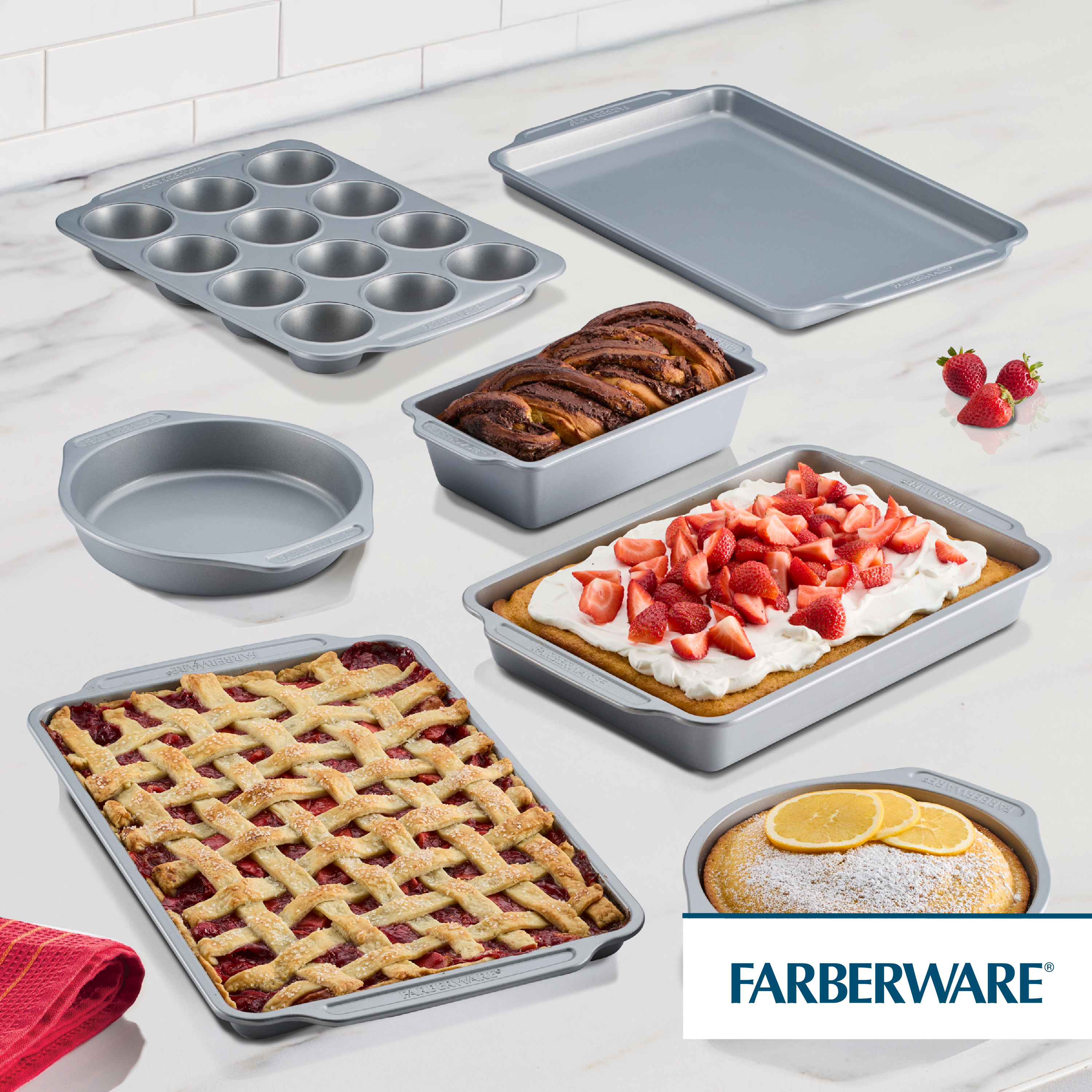 7-Piece Nonstick Bakeware Set with treats and strawberries on marble.