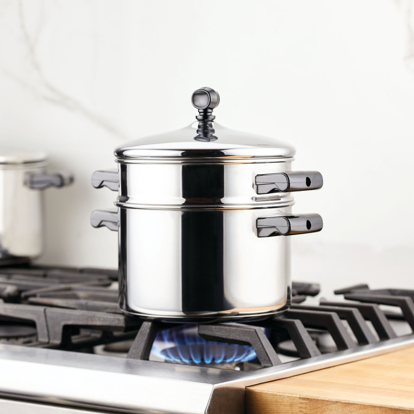 Classic Series Stainless Steel 3-Qt. Saucepot with Steamer Insert on a lit gas stove burner, ideal for pairing with your favorite dishes.