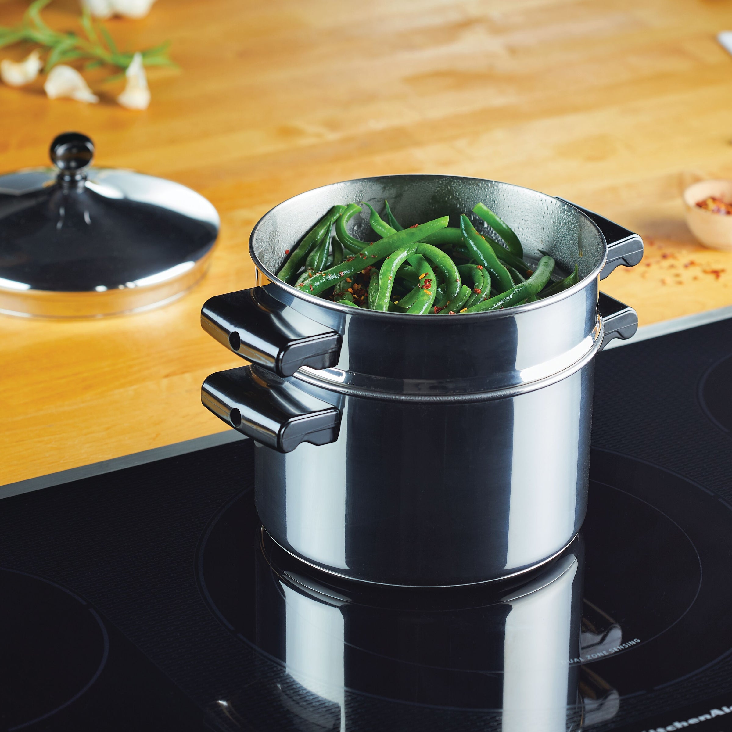The Classic Series Stainless Steel 3-Qt. Saucepot with Steamer Insert is gently cooking green beans on the stovetop.