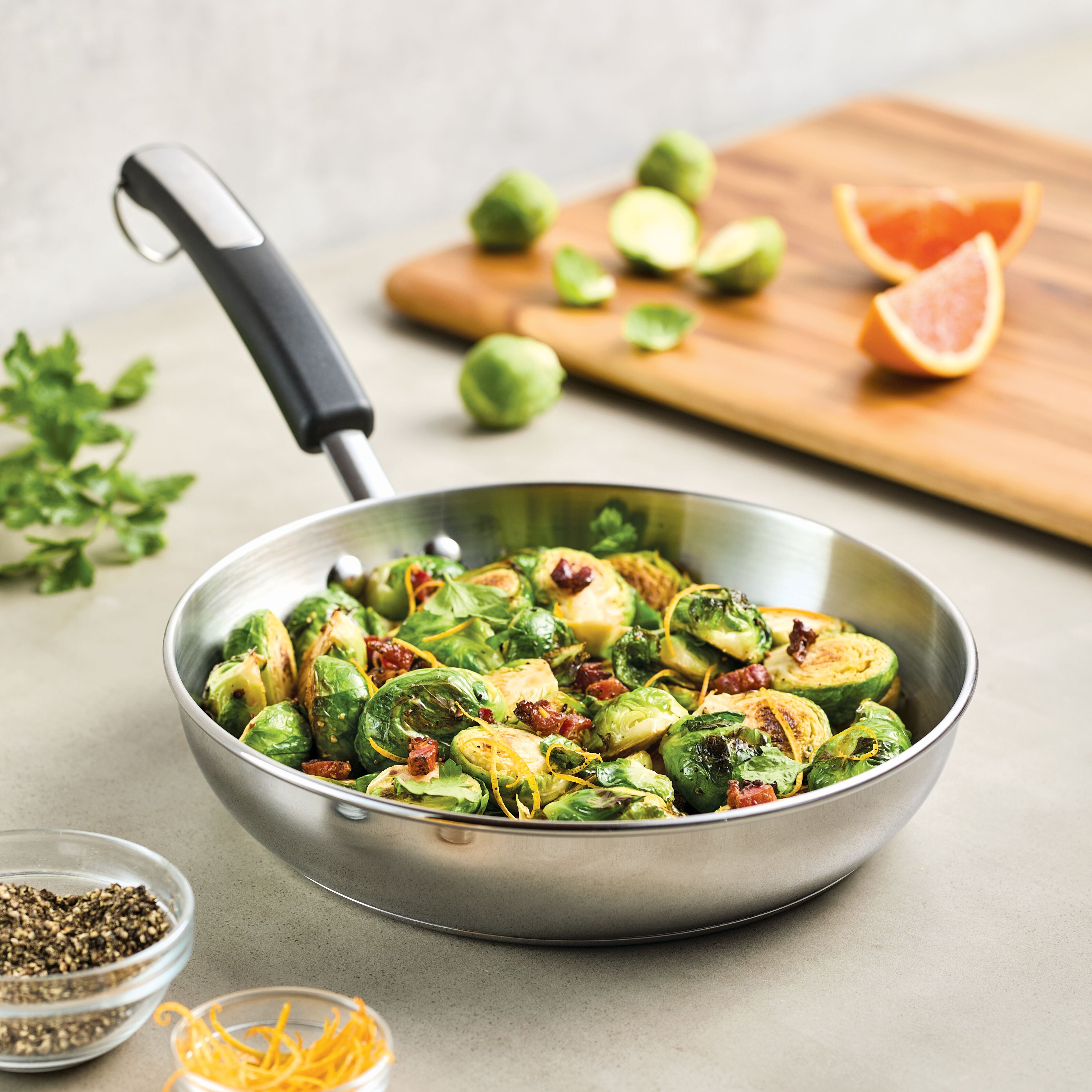 Brussels sprouts and garnish sizzle in a 10-Inch Stainless Steel Frying Pan, set elegantly on the kitchen counter.