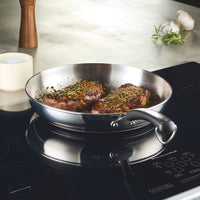 Enjoy perfectly cooked steaks on an induction stove with the 12.25-Inch Stainless Steel Frying Pan, ideal for everyday cooking.