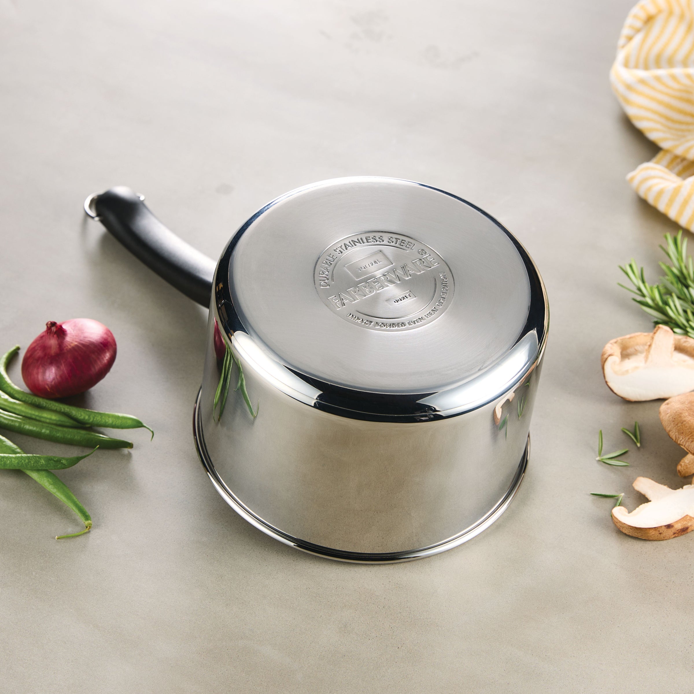 The 3-Quart Stainless Steel Saucepan rests elegantly on the table, surrounded by fresh vegetables and a cozy cloth, ready to inspire your next culinary creation.