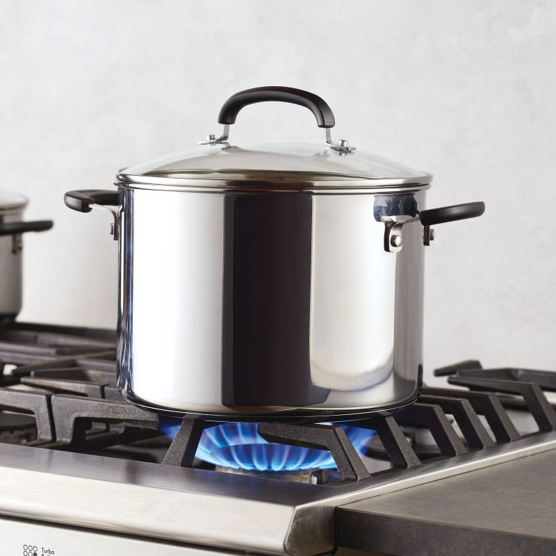 An 8-Quart Stainless Steel Stockpot heats on a gas stove’s blue flame.
