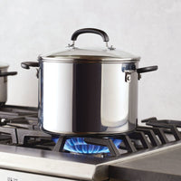 An 8-Quart Stainless Steel Stockpot heats on a gas stove’s blue flame.