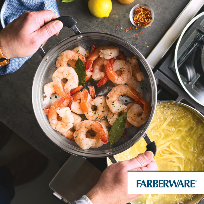 A person uses a 10 Inch Steamer Insert Stainless Steel to cook shrimp with bay leaves.