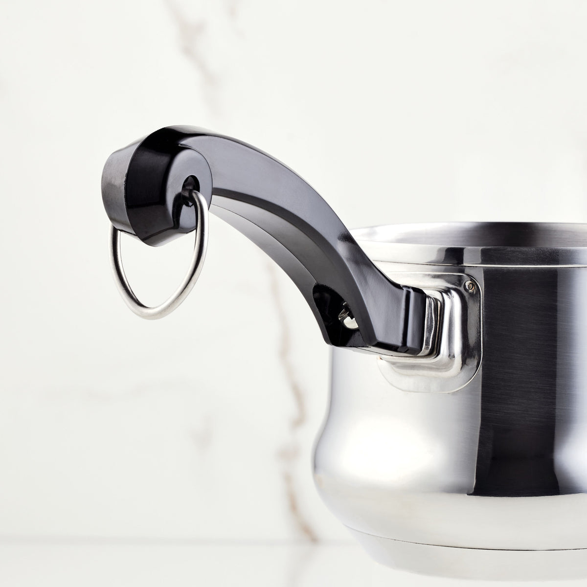 Stainless steel pot with a black handle and a metal ring on a white background.