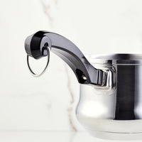 Stainless steel pot with a black handle and a metal ring on a white background.
