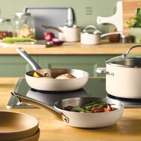 Three pans from the 14-Piece Stainless Steel Cookware Set cook on a stove.