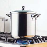 The Classic Series Stainless Steel 11-Qt. Stockpot With Lid sits elegantly on the gas stove flame, promising long-lasting performance for all your cooking needs.