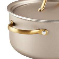 The Radiant Nonstick 5.5-Quart Dutch Oven With Lid in beige boasts a gold-colored handle and ensures excellent heat distribution for optimal cooking results.