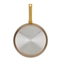 Radiant Nonstick Frying Pan in champagne color with a metal handle, highlighting its even heat distribution, viewed from the bottom side.