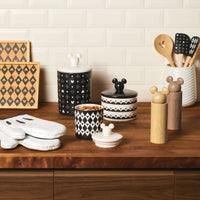 The 3 Piece Set of Ceramic Jars with Airtight Lids in black and white is elegantly displayed on a wooden countertop, capturing the timeless allure of Disney's Mickey Mouse style.