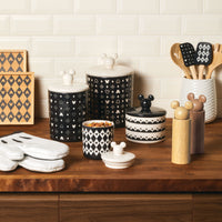 A charming kitchen counter is adorned with decorative containers, including the Ceramic Jar with Airtight Lid that features Disney's Mickey Mouse, equipped and ready with cooking utensils. The airtight lid ensures freshness while adding a touch of whimsy to your culinary space.