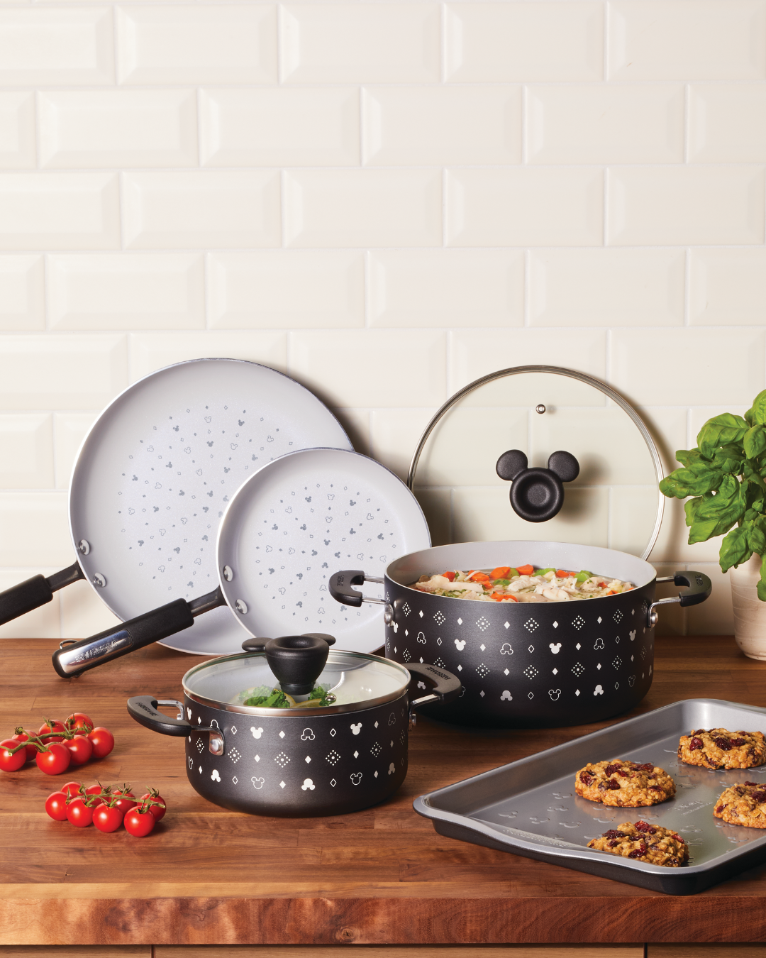 Disney Monochrome 7-Piece Cookware set in a kitchen with wooden counters and subway tile.