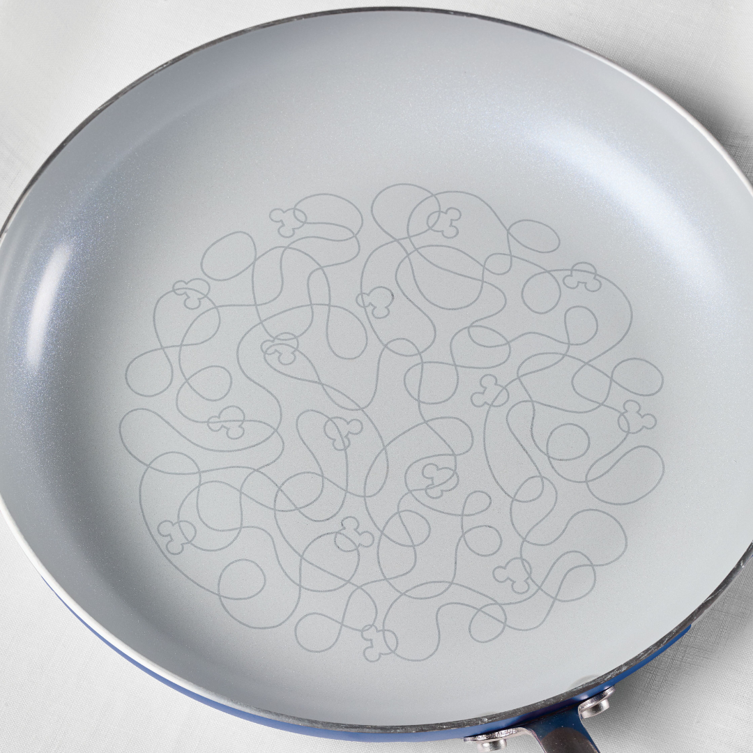 Ceramic frying pan with an intricate swirled pattern on the cooking surface.