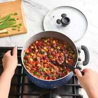Person stirring vegetable and bean stew in a pot on a stovetop.