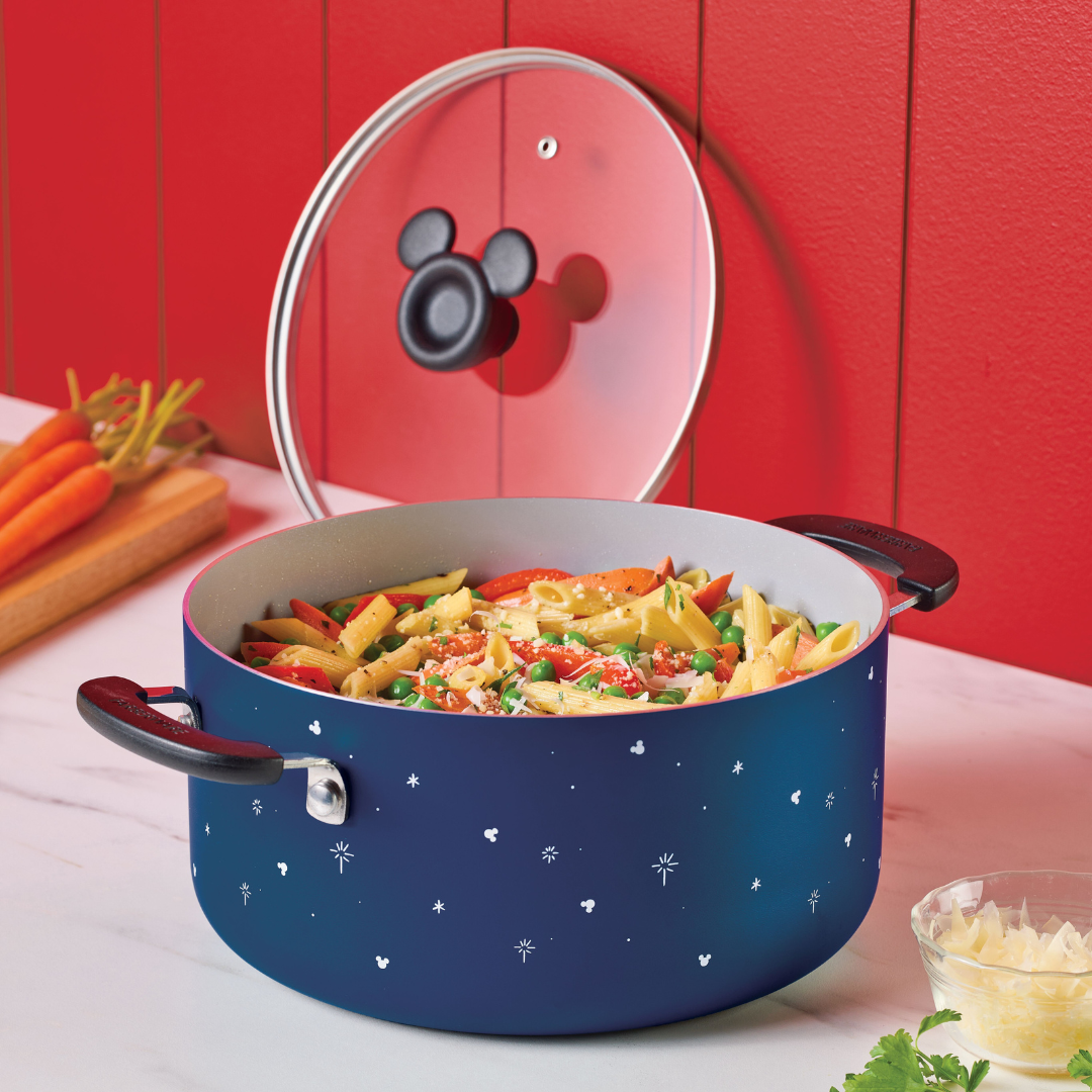 Pasta with vegetables in a decorative pot on a kitchen counter.