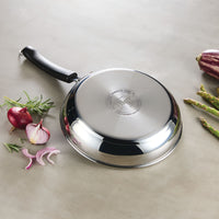 A pan from the 10-Piece Stainless Steel Cookware Set, featuring a stunning display of colorful vegetables, rests elegantly on the countertop, showcasing superior craftsmanship.