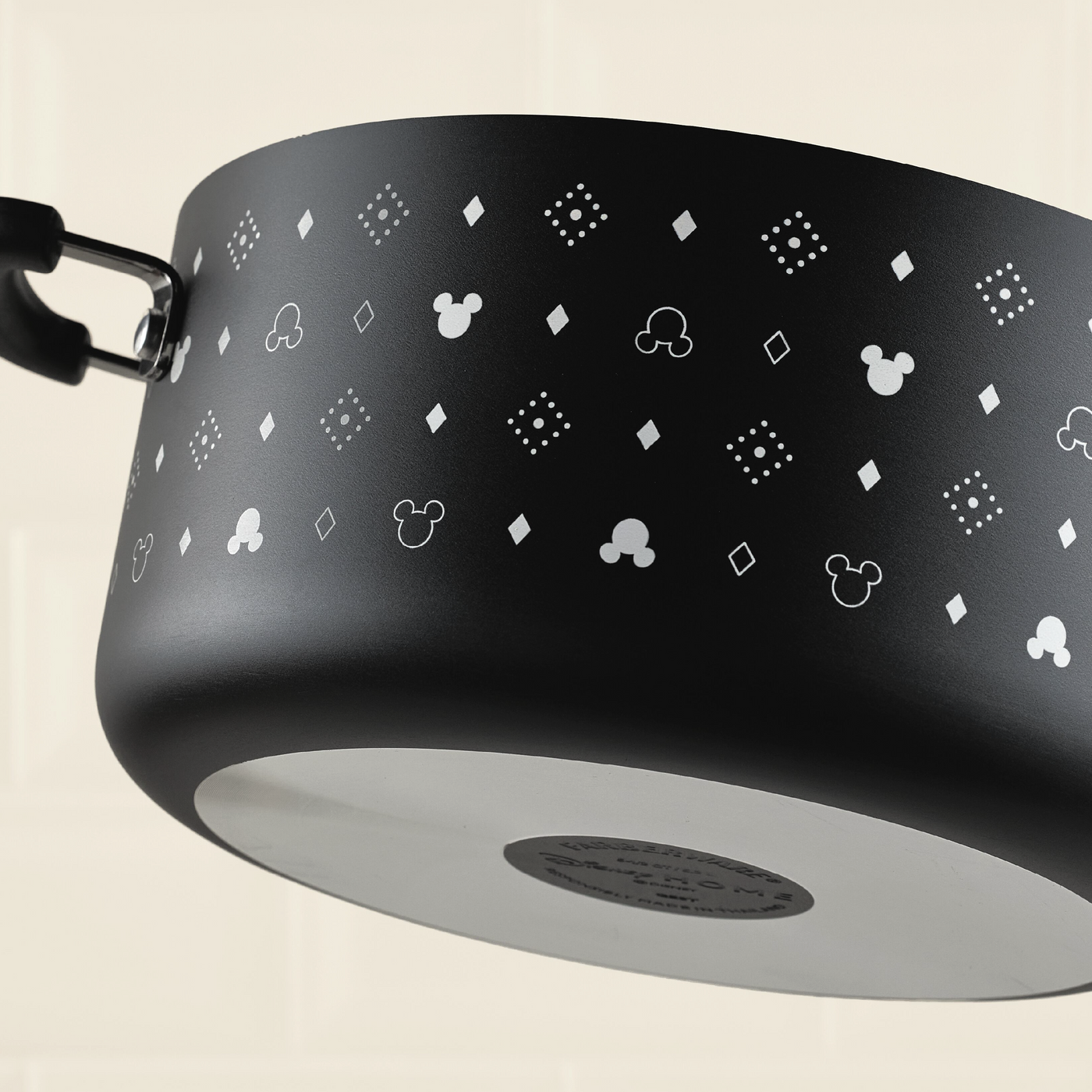 A black 5.5-quart Monochrome Ceramic Nonstick Stockpot with Lid features a white Mickey Mouse and diamond pattern on its surface.