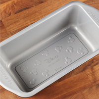 9"x5" Nonstick Loaf Pan displayed on a wooden surface, ideal for bringing a hint of Disney magic to your bakeware collection.