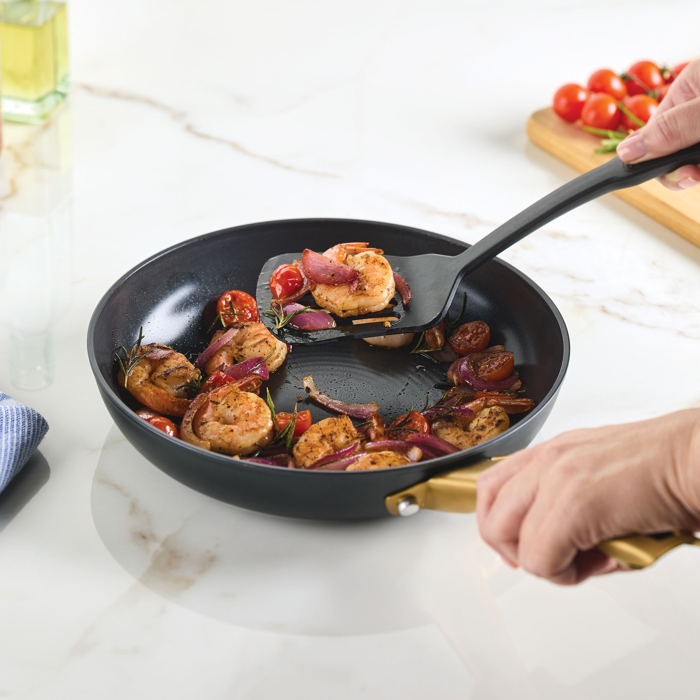 Cooking shrimp and veggies with Forged Induction Ceramic pan on marble countertop.