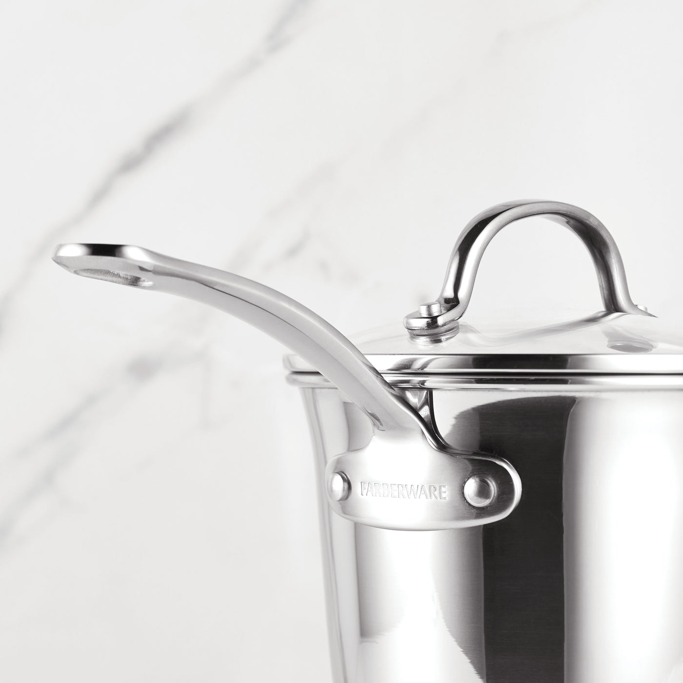 Millennium Nonstick Stainless Steel saucepan with lid and handle on a marble background, part of an oven-safe 10-piece cookware collection.