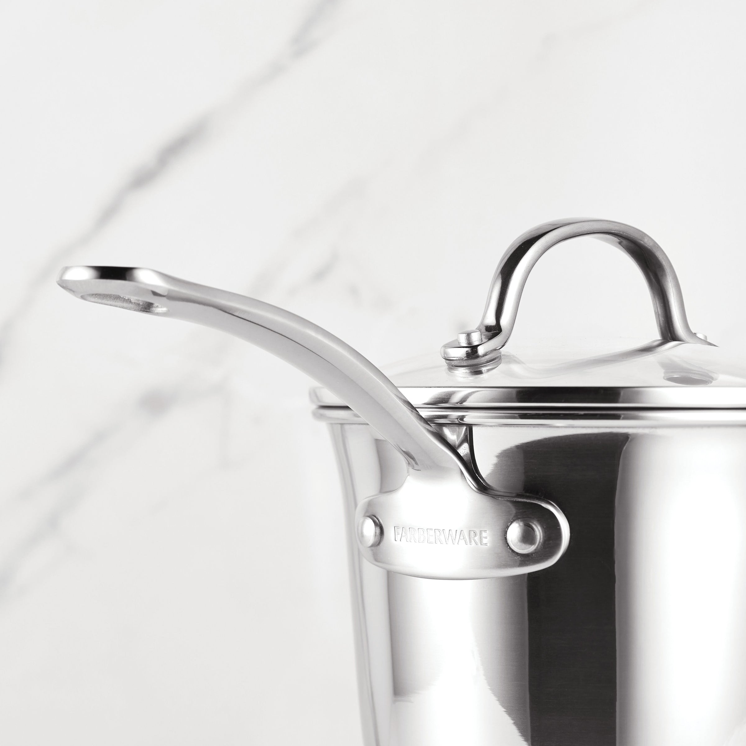 Millennium Nonstick Stainless Steel saucepan with lid and handle on a marble background, part of an oven-safe 10-piece cookware collection.