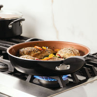 Chicken and vegetables cooking in a skillet on a gas stove.