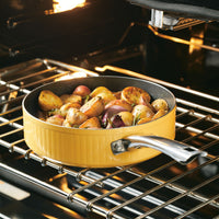 A yellow pan with roasted vegetables inside an oven.
