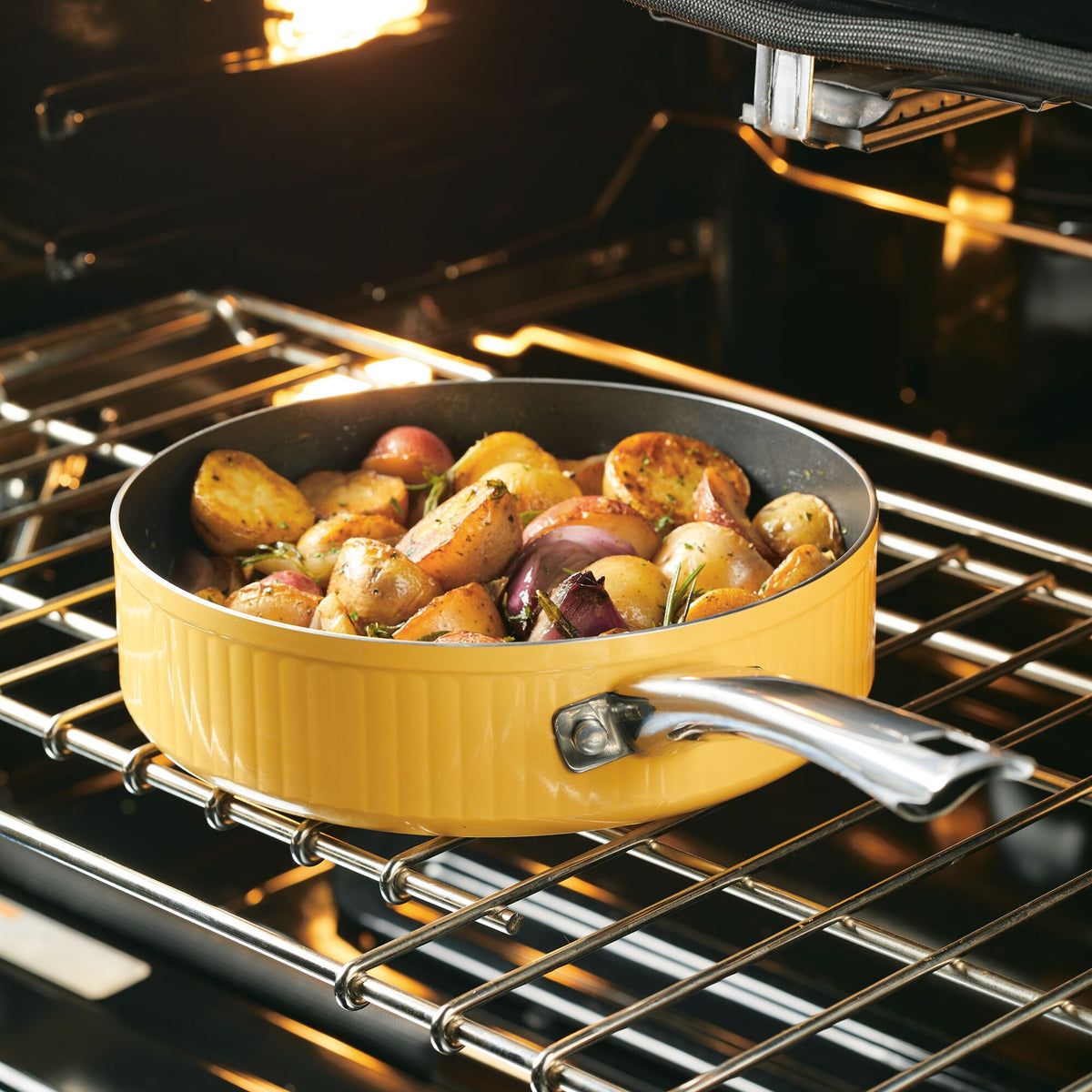 A yellow pan with roasted vegetables inside an oven.