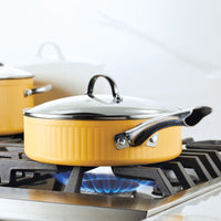 Yellow saucepan on a stovetop burner with a blue flame.
