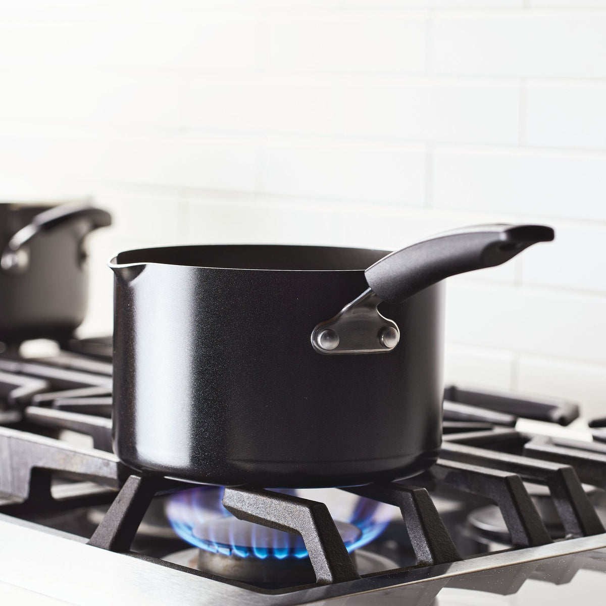 Black pot on a gas stove with blue flame.