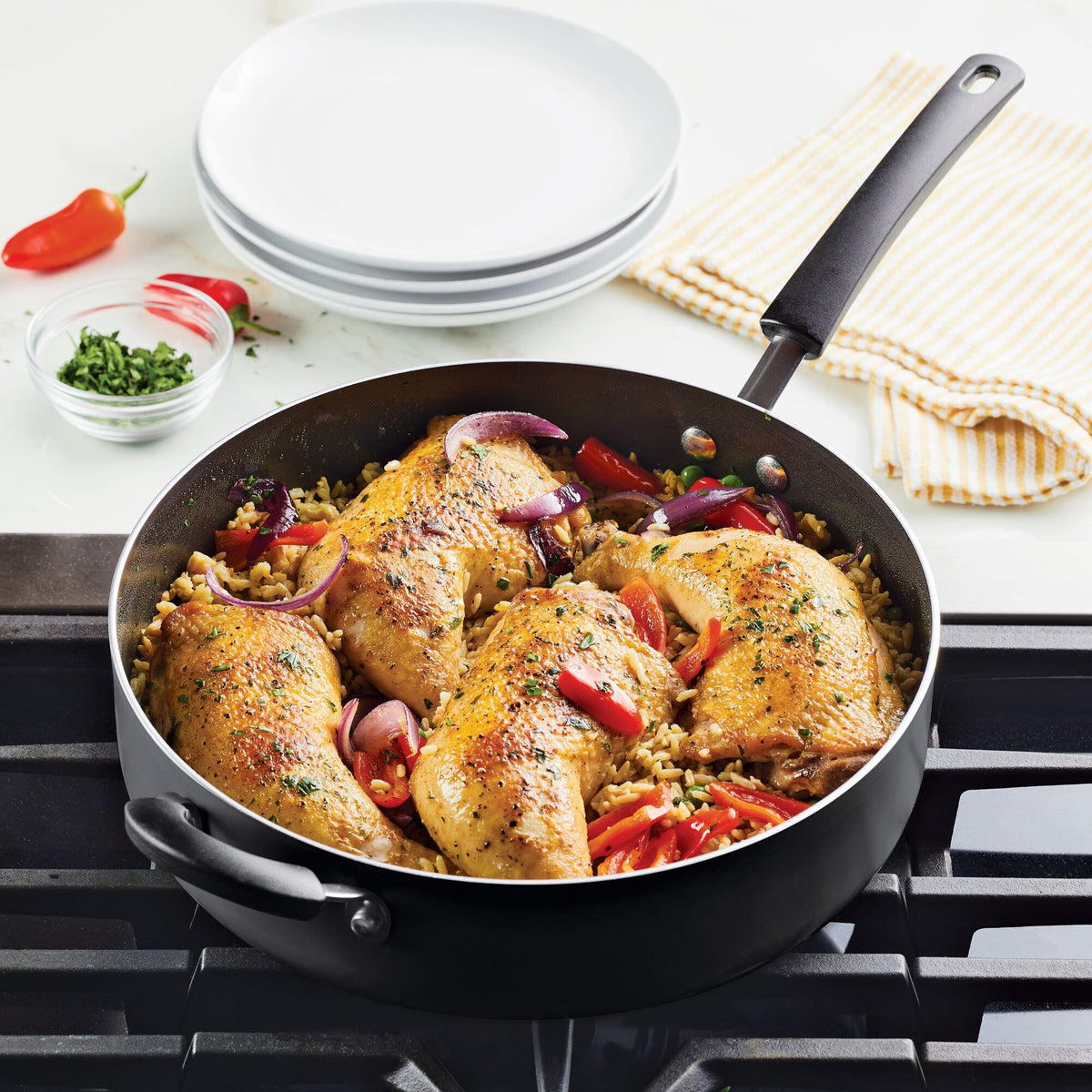 Chicken and vegetables cooking in a skillet on a stovetop.