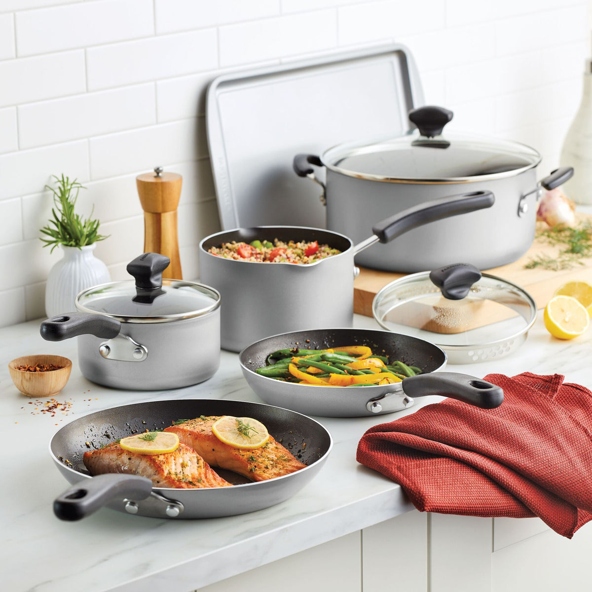 Cookware set with food on a kitchen counter.