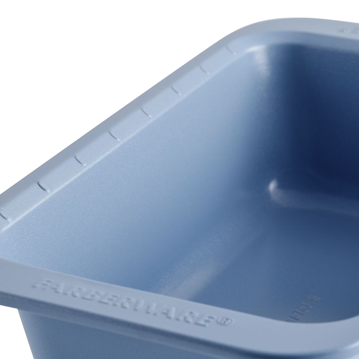 Close-up of a blue Farberware baking pan with visible ridged edges.