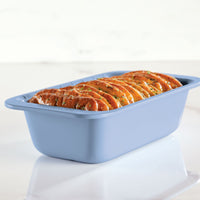 Loaf of savory pull-apart bread in a blue baking dish.