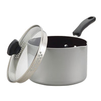 Silver saucepan with a black handle and a glass lid, tilted open.