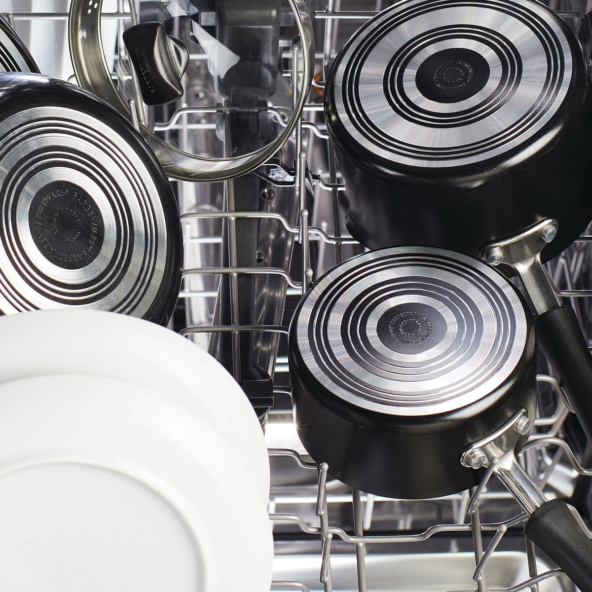 Pots and dishes arranged inside a dishwasher rack.